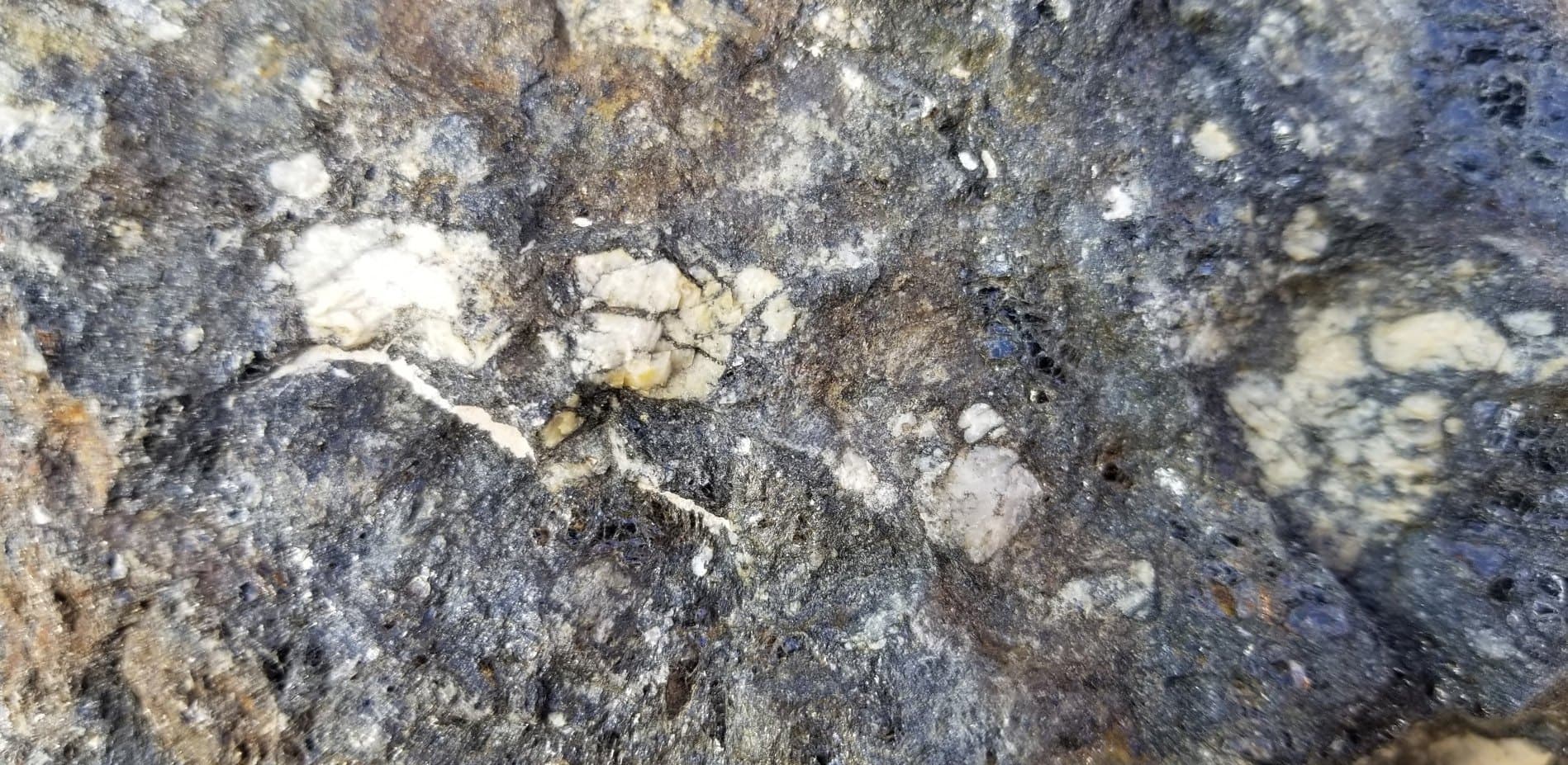 Close-up of polymetallic ore showing mineral liberation across the rock face